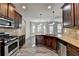 Open kitchen with granite counters, stainless appliances, and wood-look floors at 4463 Grove Lake St, Loganville, GA 30052