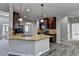 Open concept kitchen with center island, granite counters, dark cabinets, and stainless appliances at 4463 Grove Lake St, Loganville, GA 30052