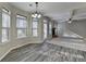 Open concept living room and dining area with fireplace, exposed beams, and wood flooring at 4463 Grove Lake St, Loganville, GA 30052