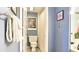 Powder room with blue walls features framed art, a toilet and towel rack at 80 La Rue Nw Pl, Atlanta, GA 30327