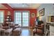 Cozy living room with red accent wall, armchairs, hardwood floors, and a door leading to the outdoors at 80 La Rue Nw Pl, Atlanta, GA 30327