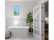 Bright bathroom with a freestanding tub, skylight, and French doors that lead to the Primary bedroom at 4340 Hadaway Nw Rd, Kennesaw, GA 30152