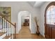 Inviting foyer featuring hardwood floors, an arched doorway, and staircase with wood railings at 4340 Hadaway Nw Rd, Kennesaw, GA 30152