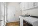 Bright laundry room with modern white cabinets and stainless steel appliances at 4340 Hadaway Nw Rd, Kennesaw, GA 30152