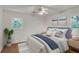 Bright bedroom featuring a ceiling fan, hardwood floors, and two large windows for natural light at 1150 Tinsley Nw Dr, Conyers, GA 30012