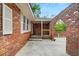 Side view of the red brick courtyard with an arched entryway and spacious concrete patio at 1150 Tinsley Nw Dr, Conyers, GA 30012