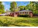 View of the charming red brick home with an expansive front lawn and inviting curb appeal at 1150 Tinsley Nw Dr, Conyers, GA 30012