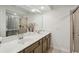Bathroom showcasing a double vanity with modern fixtures, a large mirror, and a tiled shower at 2310 Portrush Se Way, Atlanta, GA 30339