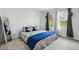 Bright bedroom featuring blue accents, a large mirror, and a sunny window overlooking a green landscape at 2310 Portrush Se Way, Atlanta, GA 30339
