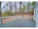 A grey back deck with a painted white railing overlooking a natural treed backyard at 240 Wrights Mill Way, Canton, GA 30115