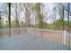 Enjoy the backyard nature views from this grey back deck with white painted railings at 240 Wrights Mill Way, Canton, GA 30115
