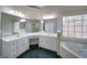 Bathroom with tub, shower, green tiled floors, and dual sinks at 240 Wrights Mill Way, Canton, GA 30115