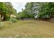 Spacious backyard with lush green grass, mature trees, and full fence at 3420 Sweetbriar Ln, Powder Springs, GA 30127