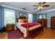 Comfortable bedroom featuring hardwood floors, neutral-colored walls, and ample natural light at 3420 Sweetbriar Ln, Powder Springs, GA 30127
