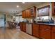Well-lit kitchen with wooden cabinets, stainless steel dishwasher, and dining nook view at 3420 Sweetbriar Ln, Powder Springs, GA 30127