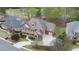 Brick home aerial view showcasing manicured lawn, professional landscaping, and extended driveway at 5224 Brendlynn Dr, Suwanee, GA 30024