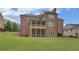 Expansive backyard with lush green lawn and brick home featuring a screened porch and patio at 5224 Brendlynn Dr, Suwanee, GA 30024