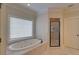 Bright bathroom showcasing a soaking tub, shower and neutral tile at 5224 Brendlynn Dr, Suwanee, GA 30024