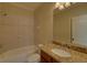 Bright bathroom featuring a shower over bath, granite countertop, and large mirror at 5224 Brendlynn Dr, Suwanee, GA 30024