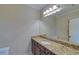 Bathroom featuring a large mirror and dark wood vanity with a granite countertop at 5224 Brendlynn Dr, Suwanee, GA 30024
