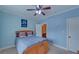 Blue bedroom with a window, ceiling fan and carpet at 5224 Brendlynn Dr, Suwanee, GA 30024
