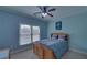 Cozy bedroom with a wood-framed bed, blue bedding, and a large window at 5224 Brendlynn Dr, Suwanee, GA 30024