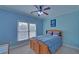 Blue bedroom with a window, ceiling fan and carpet at 5224 Brendlynn Dr, Suwanee, GA 30024