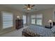 Bedroom with dual windows and neutral colors, featuring a cozy bed and dresser at 5224 Brendlynn Dr, Suwanee, GA 30024