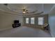 Spacious bedroom with tray ceiling, ceiling fan, and three large windows at 5224 Brendlynn Dr, Suwanee, GA 30024