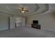 Large bedroom with a tray ceiling, ceiling fan, TV, and open access to the staircase at 5224 Brendlynn Dr, Suwanee, GA 30024