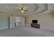 Bedroom showcasing a tray ceiling, neutral walls, and access to a balcony at 5224 Brendlynn Dr, Suwanee, GA 30024