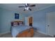 Comfortable bedroom with a wood bed frame, ceiling fan, and view of the ensuite bathroom at 5224 Brendlynn Dr, Suwanee, GA 30024