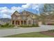 Stately two-story brick home with a covered porch, attached garage, and well-maintained front lawn at 5224 Brendlynn Dr, Suwanee, GA 30024