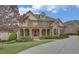 Beautiful two-story brick home featuring manicured landscaping, a welcoming porch, and a long driveway at 5224 Brendlynn Dr, Suwanee, GA 30024