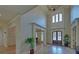 Bright foyer with hardwood floors, a soaring ceiling, and decorative plant at 5224 Brendlynn Dr, Suwanee, GA 30024