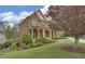 Charming brick home with manicured landscaping, inviting front porch with columns, and mature tree at 5224 Brendlynn Dr, Suwanee, GA 30024