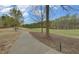 A winding sidewalk leads through the golf course, lined with mature trees and lush green fairways, perfect for an afternoon stroll at 5224 Brendlynn Dr, Suwanee, GA 30024