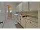 Well-lit laundry room with sink, granite counters and plenty of cabinets at 5224 Brendlynn Dr, Suwanee, GA 30024
