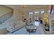 Open-concept living room with fireplace, stairway, hardwood floors and view to entry at 5224 Brendlynn Dr, Suwanee, GA 30024