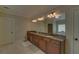Main bathroom featuring double sinks with a granite countertop, wood cabinets, and large mirrors at 5224 Brendlynn Dr, Suwanee, GA 30024