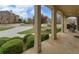 Covered porch with stone flooring, columns, and meticulously trimmed shrubbery at 5224 Brendlynn Dr, Suwanee, GA 30024