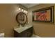 Stylish powder room features a granite countertop vanity and decorative art at 5224 Brendlynn Dr, Suwanee, GA 30024