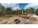 Outdoor area boasts a wooden deck, stone patio, and fire pit, surrounded by lush greenery and a wooden fence at 313 Bonnie Sue Dr, Villa Rica, GA 30180