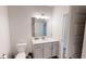 This is a bathroom with a white toilet, white vanity with quartz countertop, and mirror at 313 Bonnie Sue Dr, Villa Rica, GA 30180
