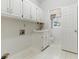 Bright laundry room with white cabinets and sink, featuring a window for natural light at 700 Henley Fields Cir, Johns Creek, GA 30097