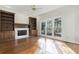 Cozy living room featuring hardwood floors, built-in bookshelves, a fireplace, and bright windows at 700 Henley Fields Cir, Johns Creek, GA 30097