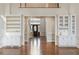 Spacious living room with hardwood floors, built-in bookshelves, and a view of the front entrance at 700 Henley Fields Cir, Johns Creek, GA 30097