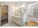 Bright bathroom with dual sinks, gold hardware, garden tub, and adjacent closet at 1885 Oak Wind Ln, Buford, GA 30519