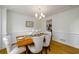 An inviting dining area showcasing panel molding, light hardwood floors, and seating for six at 1885 Oak Wind Ln, Buford, GA 30519