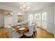 Dining room with paneled walls, chandelier, seating for six, and bay window for natural light at 1885 Oak Wind Ln, Buford, GA 30519